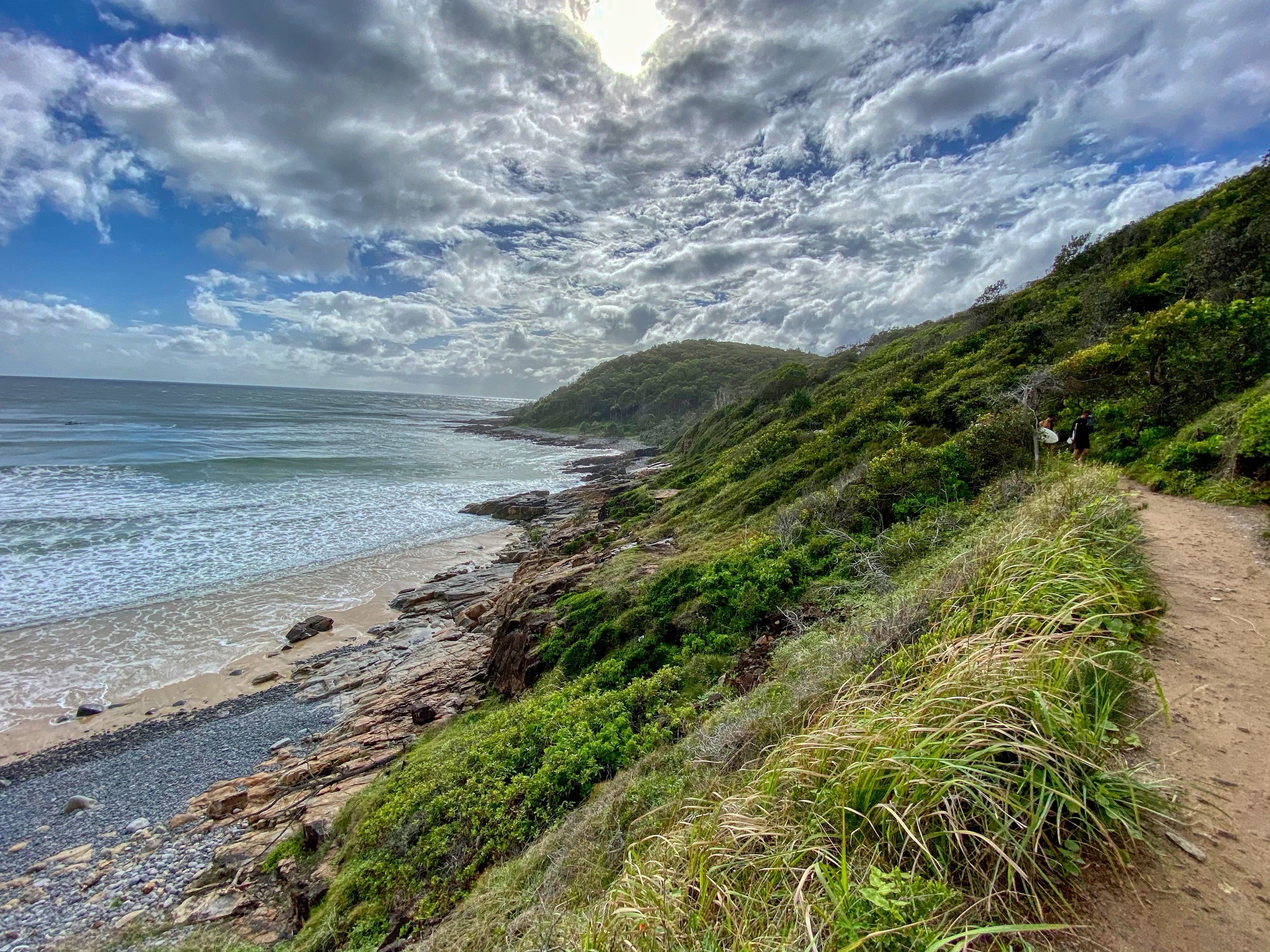 Walkers on the coastal track above a rocky shore in Noosa National Park